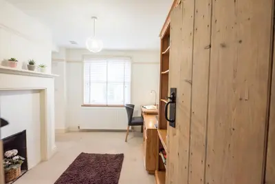 a room with a desk and a chair in a room with a fireplace at Kiln House, Snape Maltings in Snape