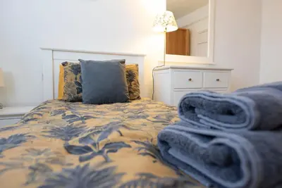 a bedroom with a bed with blue blankets on it at Kiln House, Snape Maltings in Snape