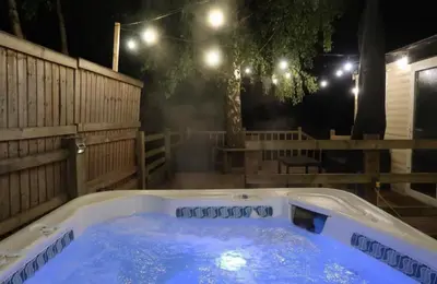 a hot tub in a backyard at night at The Duckhouse in Great Horkesley