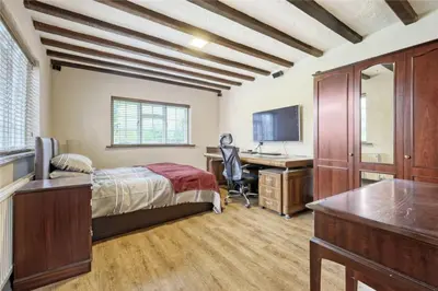 a bedroom with a bed and a desk with a computer at Blackbrook Farmhouse with free off-street parking for 10 cars in Colchester