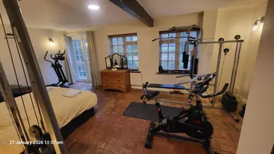 a bedroom with a gym with a bed and exercise equipment at Blackbrook Farmhouse with free off-street parking for 10 cars in Colchester