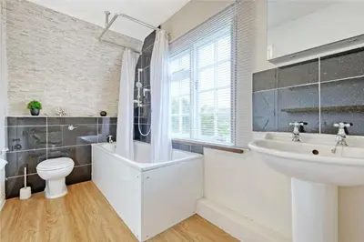 a bathroom with a sink and a tub and a toilet at Blackbrook Farmhouse with free off-street parking for 10 cars in Colchester