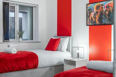 a red and white bedroom with a red and white bed at The Jockey Suite-Newmarket High Street-Two Double Bedroom Apartment in Newmarket