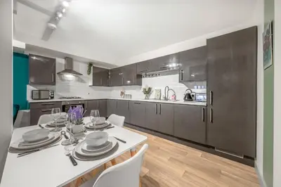 a kitchen with a white table and white chairs at The Jockey Suite-Newmarket High Street-Two Double Bedroom Apartment in Newmarket