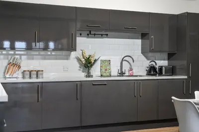 a kitchen with gray cabinets and a sink at The Jockey Suite-Newmarket High Street-Two Double Bedroom Apartment in Newmarket