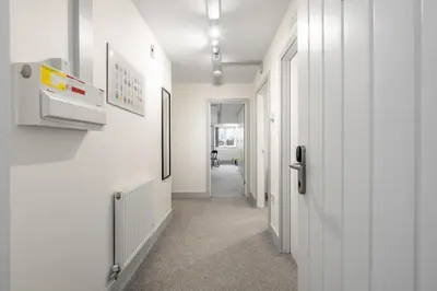 a hallway with white walls and a white hallway at The Jockey Suite-Newmarket High Street-Two Double Bedroom Apartment in Newmarket