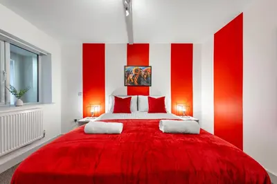 a red and white bedroom with a large bed at The Jockey Suite-Newmarket High Street-Two Double Bedroom Apartment in Newmarket
