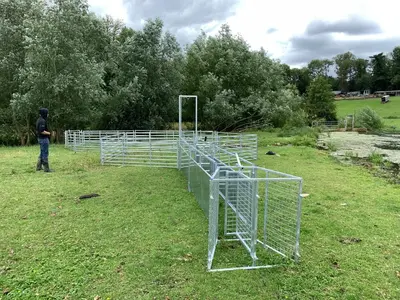 a man standing next to a metal structure in a field at Hertford farm Woodland cabin pet friendly firepit bbq in Hertford