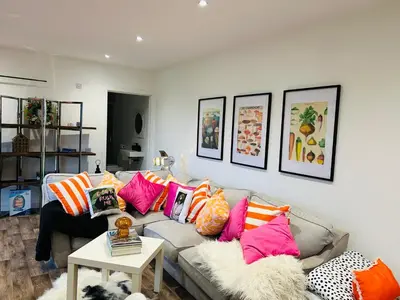 a living room with a couch with colorful pillows at Hertford farm Woodland cabin pet friendly firepit bbq in Hertford