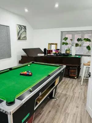 a living room with a pool table in a room at HERTFORD House with garden parking pet friendly pool room in Hertford