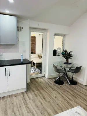 a living room with a table and a kitchen at HERTFORD House with garden parking pet friendly pool room in Hertford