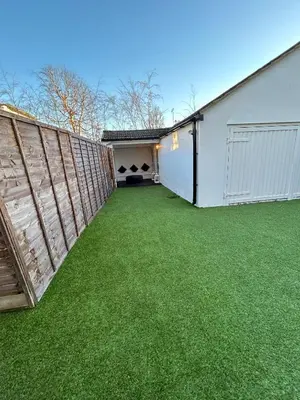 a backyard with a fence and green grass at HERTFORD House with garden parking pet friendly pool room in Hertford