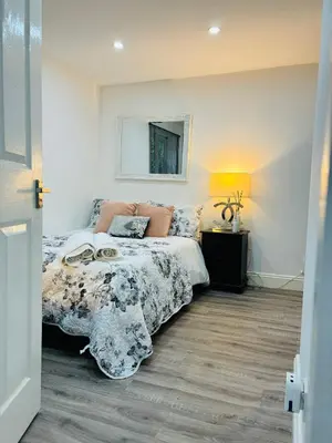 a bedroom with a bed and a mirror on the wall at HERTFORD House with garden parking pet friendly pool room in Hertford