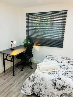 a bedroom with a desk and a bed and a desk chair at HERTFORD House with garden parking pet friendly pool room in Hertford