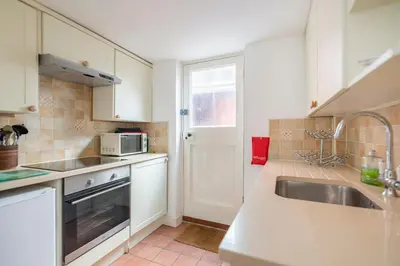 a kitchen with a sink and a microwave at Ann Page Cottage, Aldeburgh in Aldeburgh