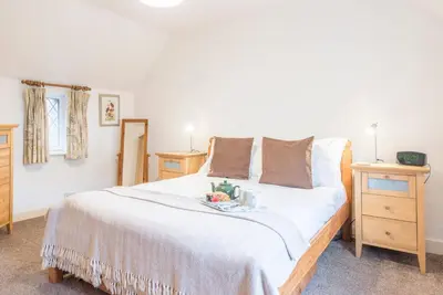 a bedroom with a large white bed with a tray on it at Ann Page Cottage, Aldeburgh in Aldeburgh