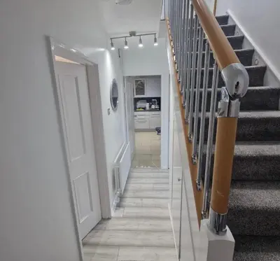 a hallway with a stairway with a stair railing at Cosy large double room in Basildon