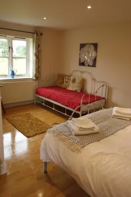 a bedroom with two beds and a red couch at The Eelsfoot inn in Theberton