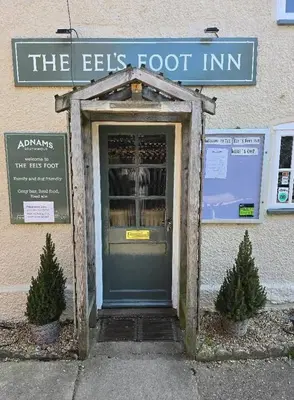 a door into a building with a sign on it at The Eelsfoot inn in Theberton