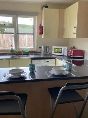 a kitchen with a counter top with two cups and plates at Two Bedroom Bungalow No2 - Secure Gated Parking in Basildon