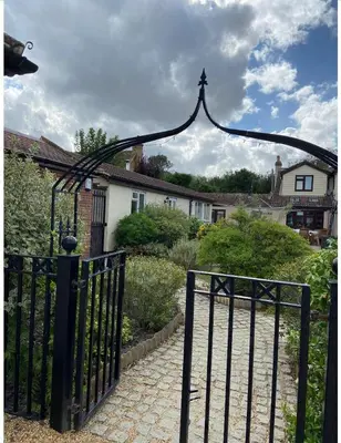 a black gate leading to a driveway with a house at Two Bedroom Bungalow No2 - Secure Gated Parking in Basildon