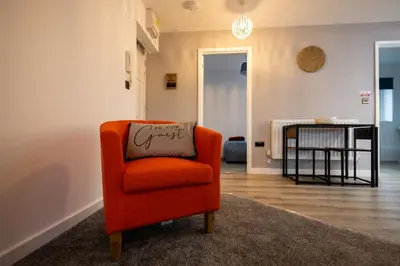 an orange chair sitting in a living room at Kingfisher in Haverhill