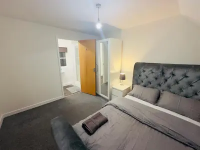 a bedroom with a large bed and a couch at Comfortable Double Rooms in a Beautiful House in Ipswich