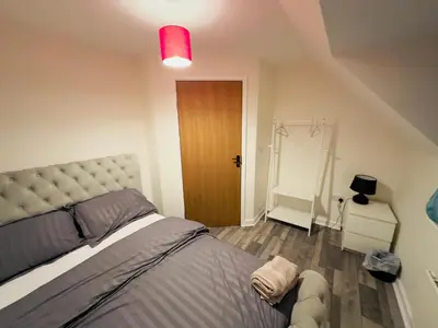 a bedroom with a large bed and a red light at Comfortable Double Rooms in a Beautiful House in Ipswich