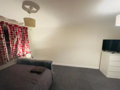 a living room with a couch and a flat screen tv at Comfortable Double Rooms in a Beautiful House in Ipswich