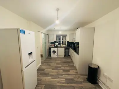 a kitchen with a white refrigerator and a tile floor at Comfortable Double Rooms in a Beautiful House in Ipswich