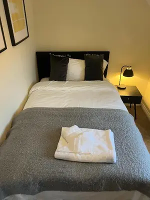 a bed with a white towel sitting on top of it at Grange Luxe 4 in Martlesham Heath