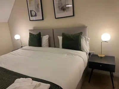 a bedroom with a large white bed with two lamps at Grange Luxe 4 in Martlesham Heath