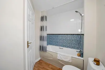 a bathroom with a tub and a toilet and a sink at Grange Luxe 4 in Martlesham Heath