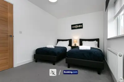 a bedroom with two beds and a sign on the wall at Charming 2 BDR House By AR Properties Short Lets & Serviced Accommodation Colchester in Colchester