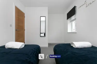 a bedroom with two beds and a window and a door at Charming 2 BDR House By AR Properties Short Lets & Serviced Accommodation Colchester in Colchester