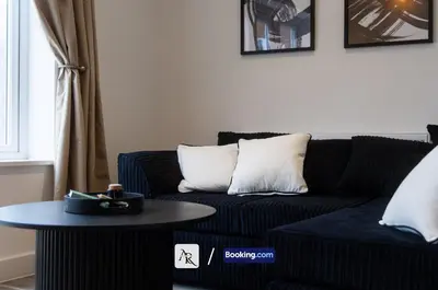a living room with a black couch and a table at Charming 2 BDR House By AR Properties Short Lets & Serviced Accommodation Colchester in Colchester