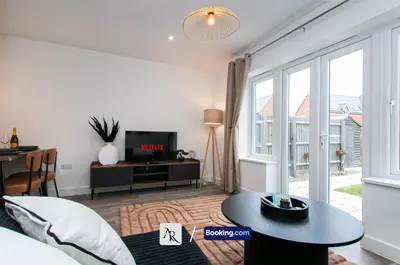 a living room with a bed and a table and a tv at Charming 2 BDR House By AR Properties Short Lets & Serviced Accommodation Colchester in Colchester
