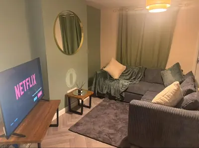 a living room with a couch and a tv at Newly decorated Cozy home! in Hythe