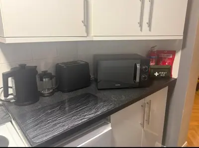a kitchen counter with a microwave and a coffee maker at Newly decorated Cozy home! in Hythe