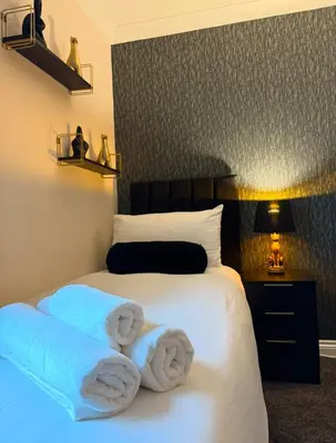 a bedroom with a bed with towels on it at Newly decorated Cozy home! in Hythe