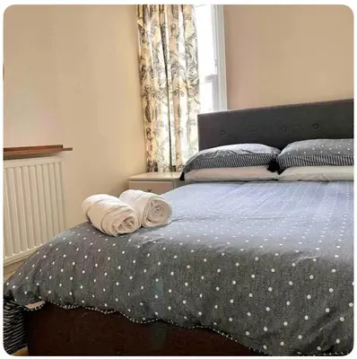 a bedroom with a bed with two towels on it at Tardis Vibes in Stowmarket