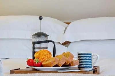 a plate of bread and fruit on a tray on a bed at 2 Bed in Wickhambrook oc-b30507 in Wickhambrook