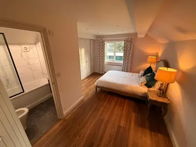 a bedroom with a bed with a lamp and a window at The Old Coach House in Hockwold cum Wilton
