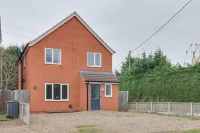 a red brick house with a blue door at Blackwater Villa Witham in Witham