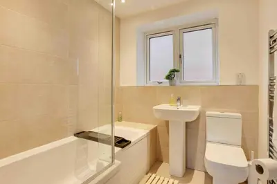 a bathroom with a sink and a toilet and a shower at Blackwater Villa Witham in Witham