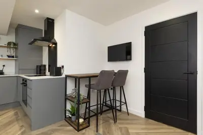 a kitchen with a small table and two stools at Flat in Royston Town Centre in Royston