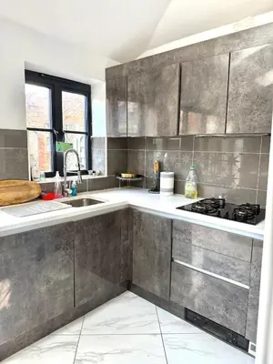 a kitchen with gray cabinets and a sink at Rose home in Haverhill