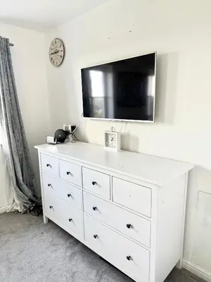 a white dresser with a tv on top of it at Rose home in Haverhill
