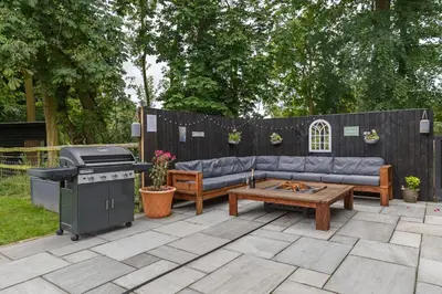 a backyard with a couch and a grill and a table at 4 Bed in Saham Toney oc-o30348 in Saham Toney