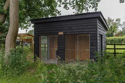 a black shed with a gate in a field at 4 Bed in Saham Toney oc-o30348 in Saham Toney